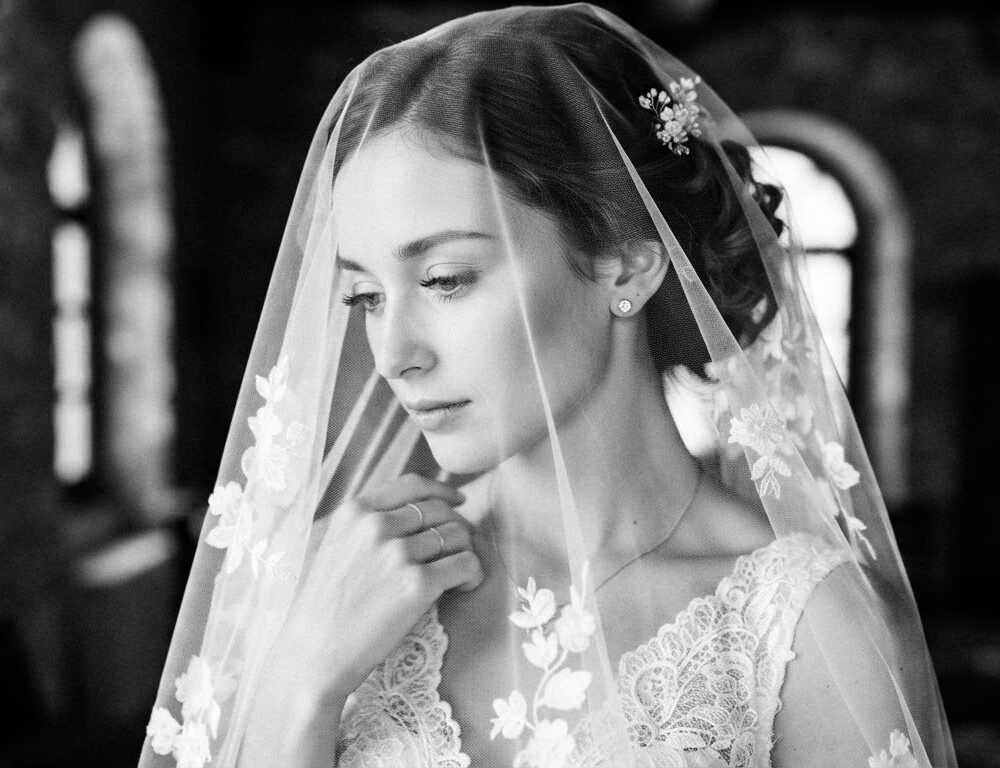 A serene black and white close-up portrait of a bride and her veil.